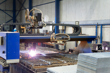 Plasma cutter cutting steel plates in modern construction factory