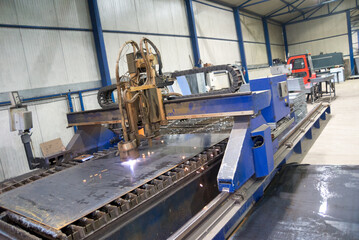 Plasma cutter cutting steel plates in modern construction factory