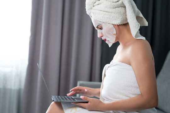 A woman works with a laptop during a cosmetic procedure, remote work mode, cosmetology procedures with a face.