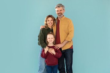 Cheerful Middle Aged Parents And Daughter Hugging Over Blue Background