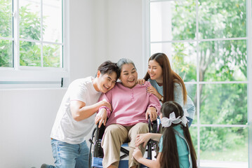 Happy asian family spending time together on vacation at home, grandmother on wheelchair with...