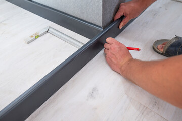 Wooden plinth in the room, installation of the plinth by a master carpenter.