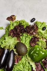 Healthy organic food, diet concept.
Beautiful raw vegetables assortment on a lettuce. Top view, copy space. Avocado, eggplant, grape and pepper