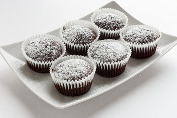 Several chocolate muffins on the white square plate
