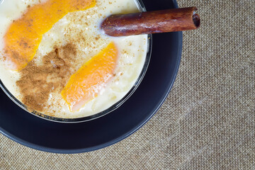Delicious rice pudding with cinnamon and with a touch of orange, presented in a bowl.