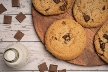 Chocolate chip cookies on wooden background with ingredients