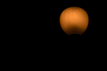 light from artistic orange lamp on black background