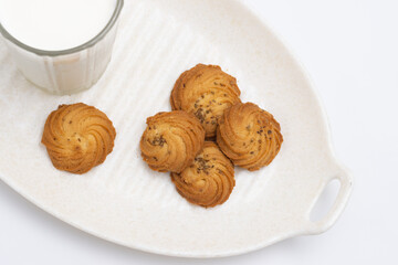Cookies or biscuits and glass of milk on a serving tray for breakfast or snacks, a healthy concept lifestyle with copy space for text isolated on white background