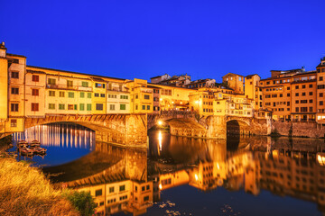 Fototapeta na wymiar Illuminated Ponte Vecchio Bridge with Reflection in Arno River at Dusk, Florence