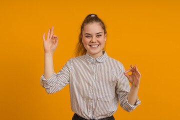 young teen girl showing ok sign on color background