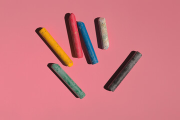 colored crayons on a pink background in hard light