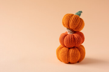 Knitted orange pumpkins on an orange background, autumn composition, front view. Halloween concept.