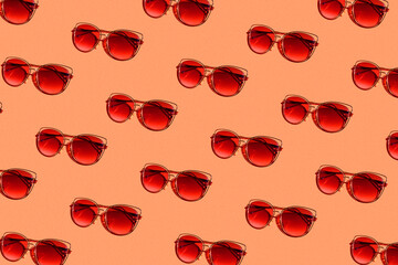 pattern of sunglasses with red lenses on an orange background with hard light