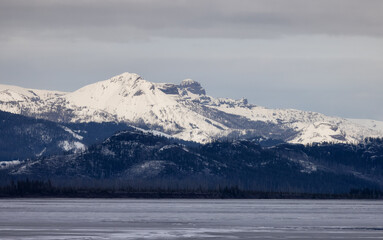 View of a frozen Yellowstone Lake with snow covered mountains in American Landscape. Yellowstone National Park. United States. Nature Background.