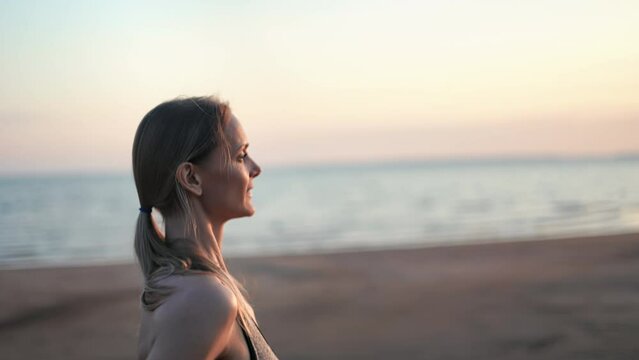 Happy athletic blonde woman running jogging sunset beach nature landscape slow motion 