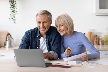 Happy pensioners sittting in front of computer, reading emails