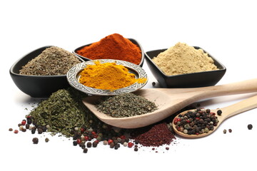 Turmeric powder, ginger ground, red paprika, anise seeds, colorful pepper, dry basil in wooden spoon, pile sumac and dry chopped parsley isolated on white