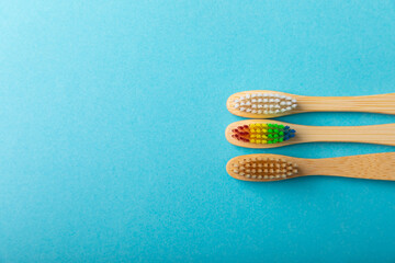 Toothbrushes. Oral care. Dental care. Composition with bamboo toothbrushes on a blue background. Eco friendly.Copy space. Place for text.Fletley