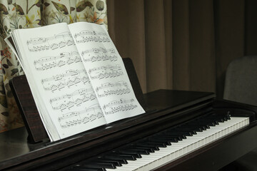black piano and sheet music, at home