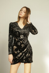 Serie of studio photos of young female model in black textured velvet  dress, autumn fashion collection.