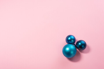 blue Christmas toys balls on a pink background. Minimalistic background