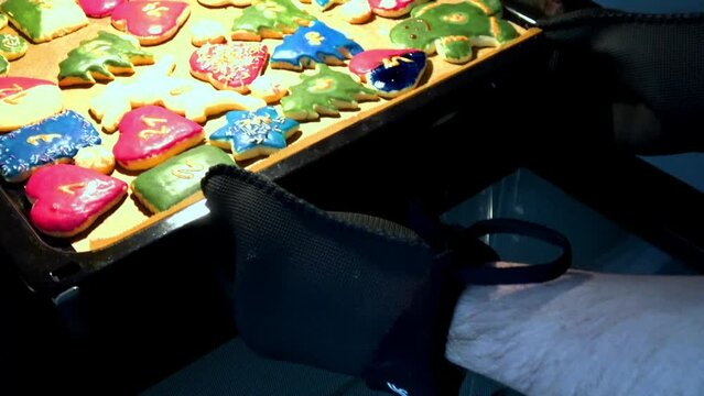 frisch gebackene Pl&auml;tzchen werden aus dem Backofen geholt