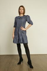 Serie of studio photos of young female model in cotton denim peter pan collar dress	