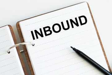 INBOUND text on a sheet of open notepad on a desk