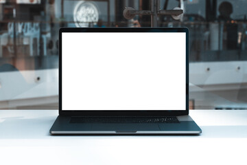 Laptop mockup with white screen in business office or shopping mall. Empty copy space, blank screen mockup. Soft focus laptop with interor background. Travel, study and office work concept