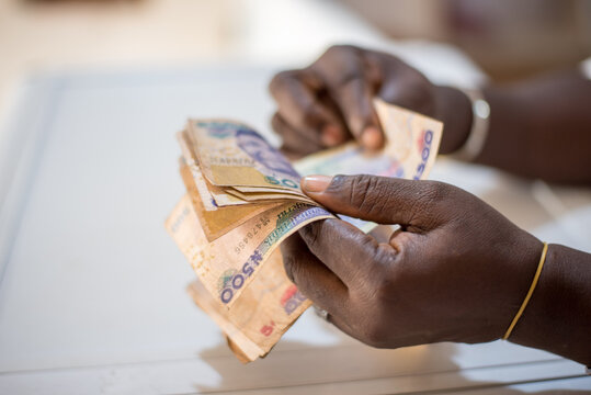 A woman holds 500 naira notes as she counts - money in hand