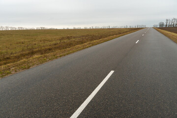 Empty asphalt road close-up against the sky. Empty background, space for text. New asphalt concrete pavement in rural areas.