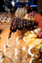 glasses with red wine and fruits on the table