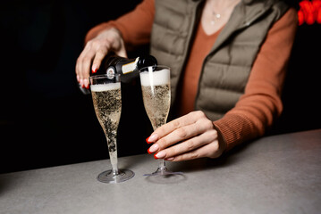 People clinking glasses of champagne against blurred background, closeup. Bokeh effect