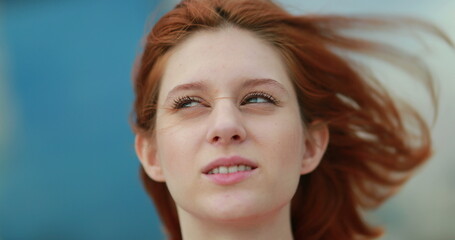 Fototapeta premium Redhair woman feeling wind blowing in face