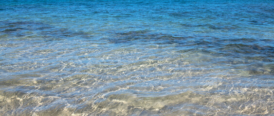 Summer sea background. Texture of water surface. Shining blue water ripple pattern.