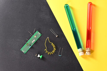 Electrical parts and chemical laboratory glass on the dark background.