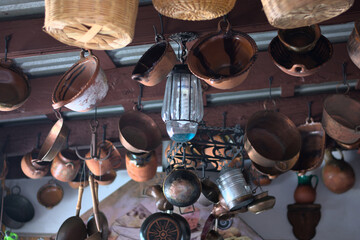 Fototapeta na wymiar Pots, vases and other kitchen utensils hanging from the ceiling.