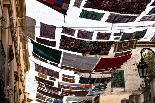 Large colored crochet cloth suspended between the buildings of the city of Rossano in Calabria.