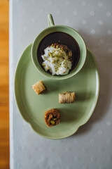 drinking chocolate in matching green cup and plate with assorted baklava desserts