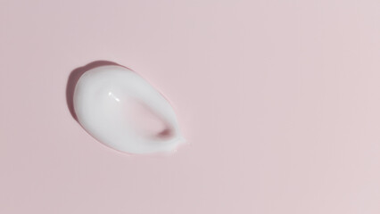 White cosmetic cream texture on pink background