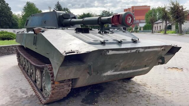 Tank in the war. A tracked self-propelled military howitzer stands on a city street. Russian artillery howitzer. A destroyed Russian howitzer during the war in Ukraine.