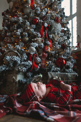 Little boy celebrates christmas in a decorated room