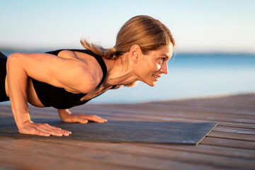 Athletic Middle Aged Woman Doing Plank Exercise Or Push Ups Outdoors, Closeup