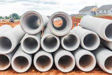 new concrete pipes stacked on a construction site. Preparation for the manufacture of the sewer system.