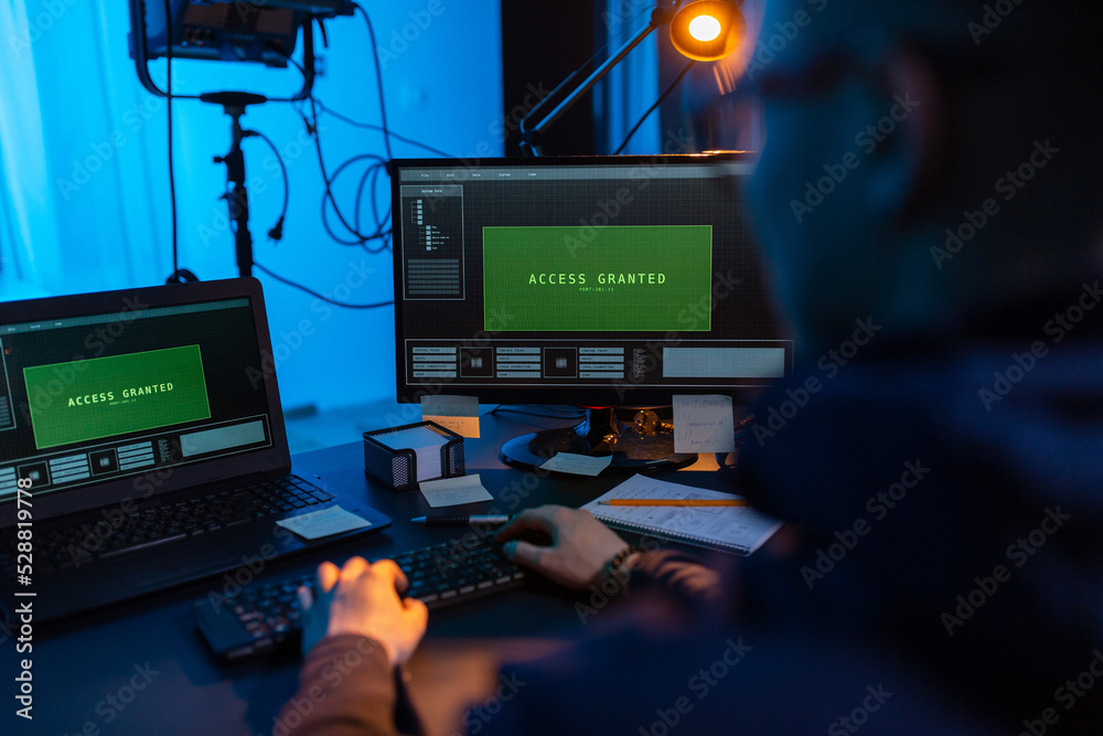 Poster cybercrime, hacking and technology concept - close up of male hacker in dark room writing code or us