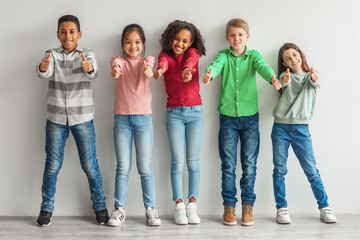 Group Of Happy Diverse Children Gesturing Thumbs Up Indoor
