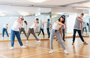Teenagers boy and girls performing hip hop at group dance class
