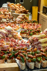 Typical snack of Basque Country and Navarre, pinchos or pinxtos, small piece of bread with different toppings, served in bar, Bilbao, Spain