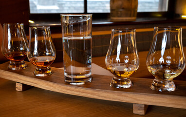 Flight of single malt scotch whisky in glasses served in whiskey bar in Edinburgh, UK