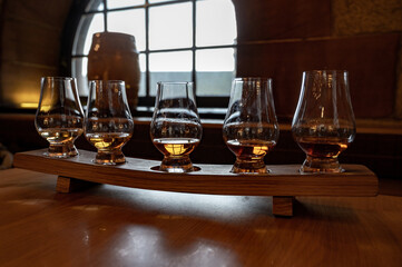 Flight of single malt scotch whisky in glasses served in whiskey bar in Edinburgh, UK